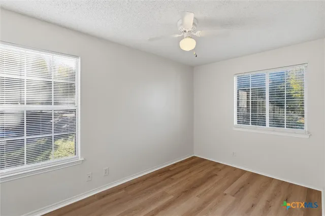 a view of empty room with wooden floor