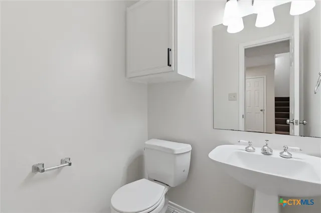 a bathroom with a sink a toilet and a mirror