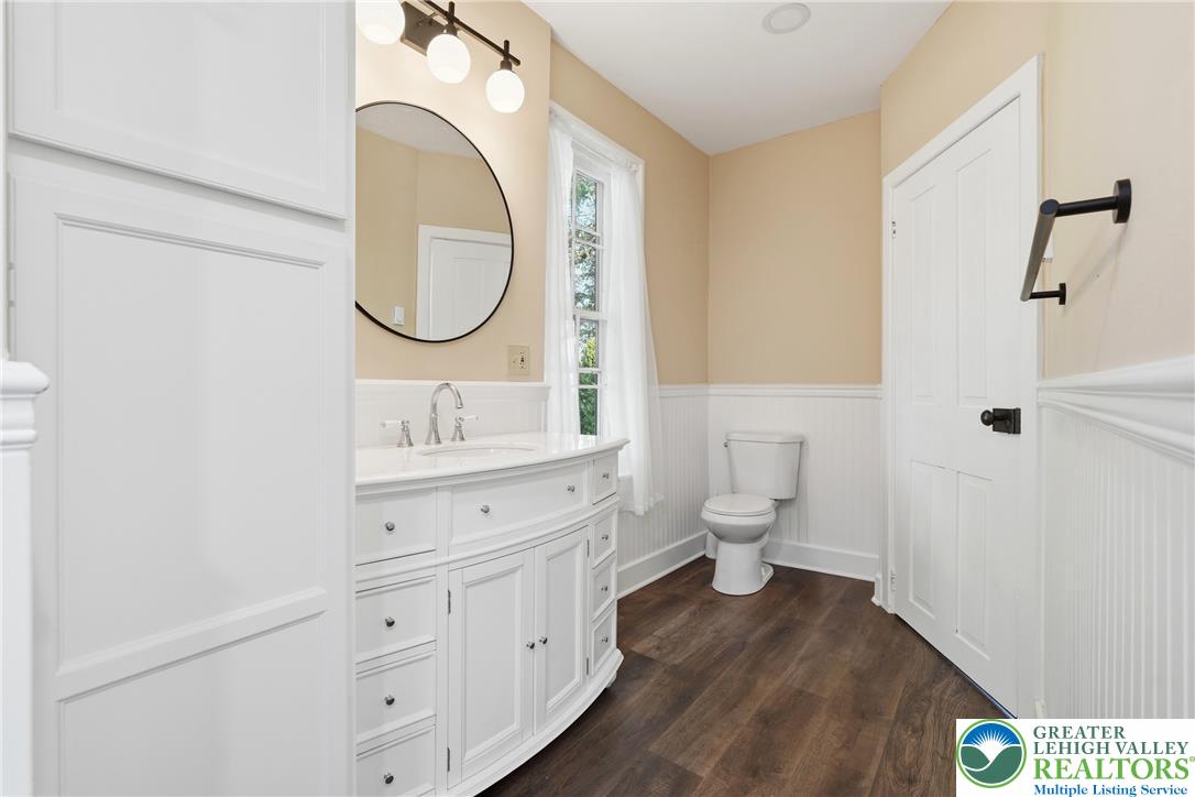 4682 Steuben Road Bethlehem, PA 18020 - Photo 34 of 79 A well-lit bathroom features a vanity with a large mirror and rich, wood-tone flooring.