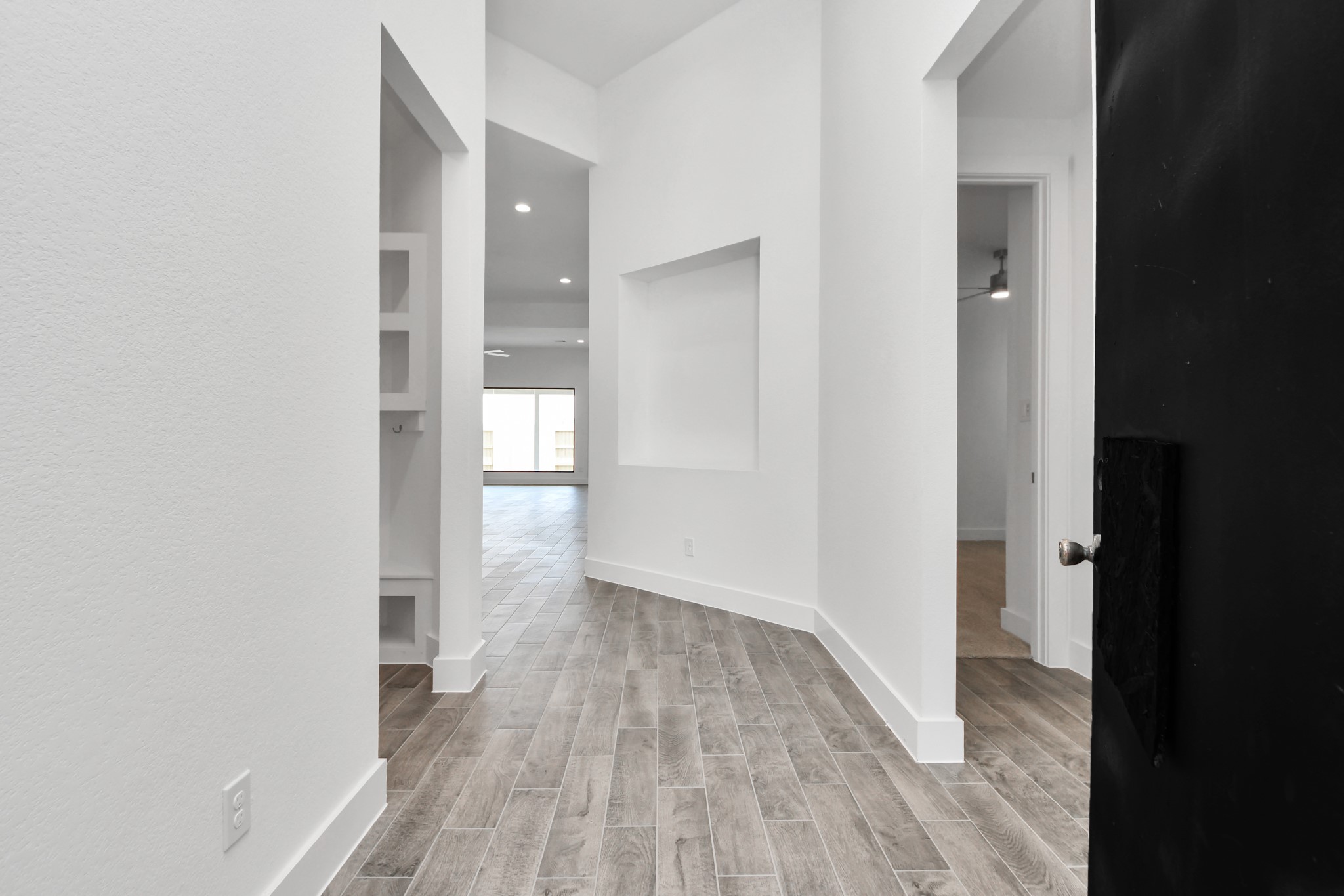 3046 Native Spg Drive Spring, TX 77373 - Photo 10 of 35 As you step into the threshold of this luxurious home, you'll soon be welcomed by an elegant glass door (to be installed). Inside, soaring ceilings amplify the spaciousness, while the refined wood-look tile flooring and oversized baseboards exude sophistication and charm. Sample photo of completed home with similar floor plan. Actual colors and selections may vary.
