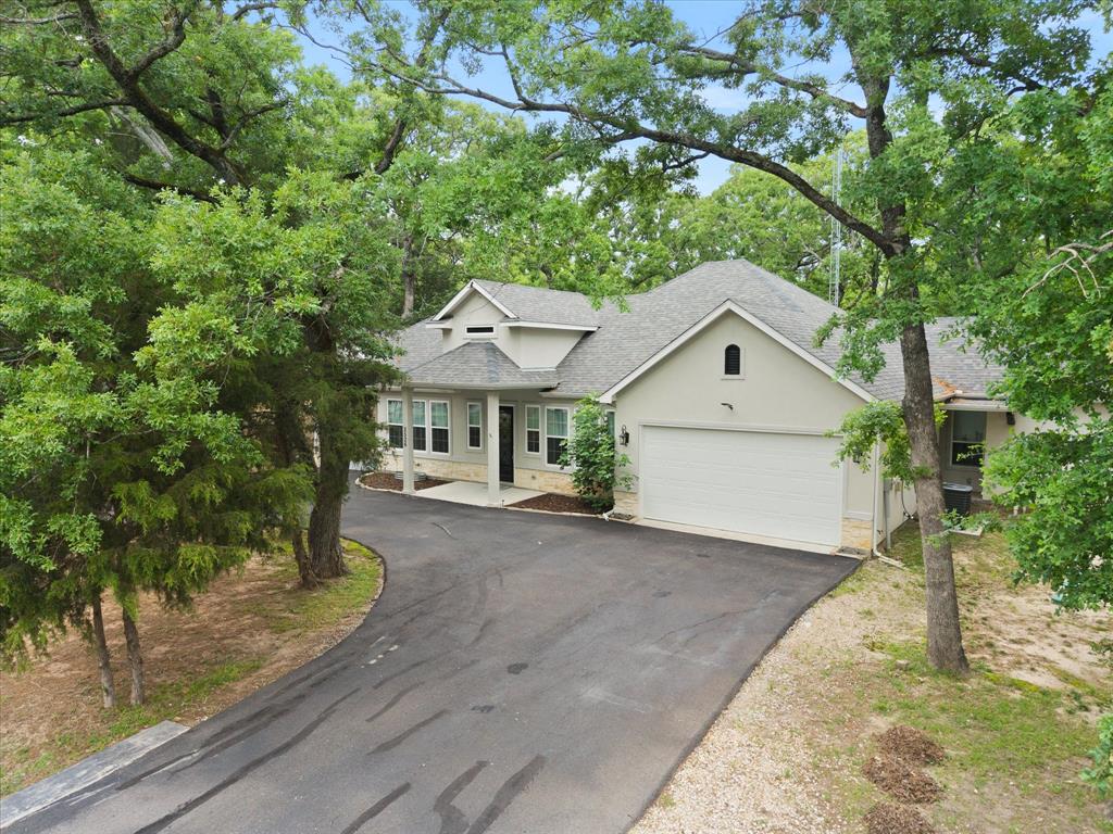 2526 Fox Point Circle Quinlan, TX 75474 - Photo 2 of 35 Nestled among towering trees, this meticuously maintained home awaits your arrival!