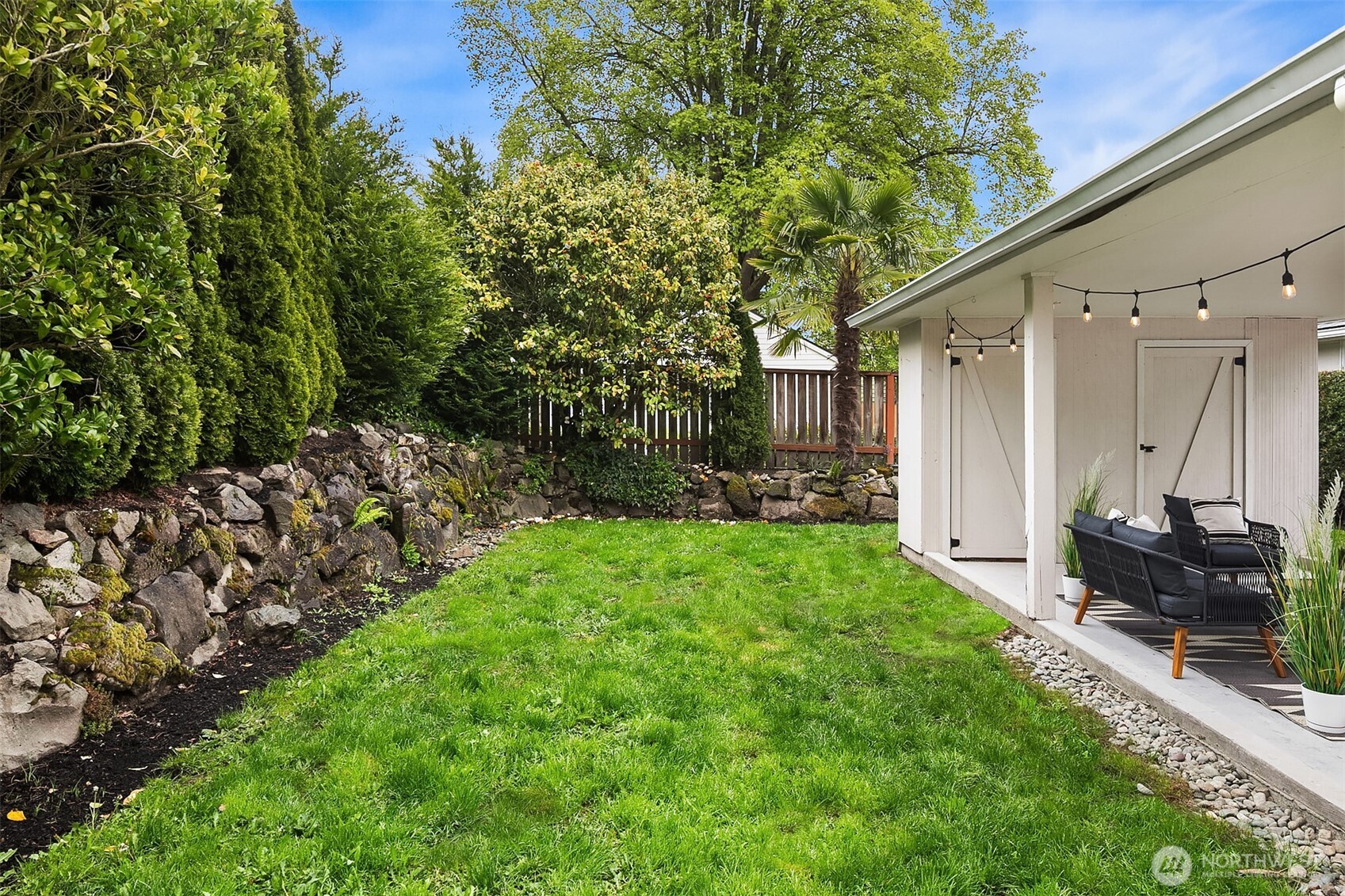 726 North 86th Street Seattle, WA 98103 - Photo 24 of 31 a view of a backyard with potted plants and large trees