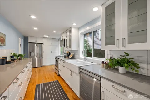 a kitchen with sink refrigerator and large window