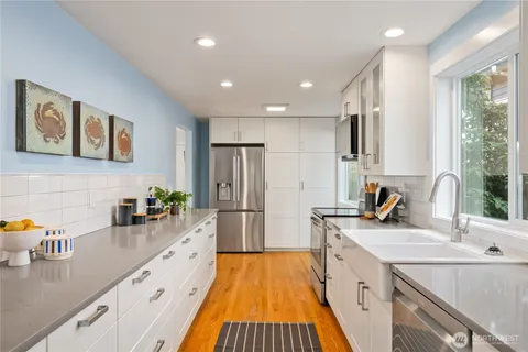 a kitchen with sink a refrigerator and wooden cabinets
