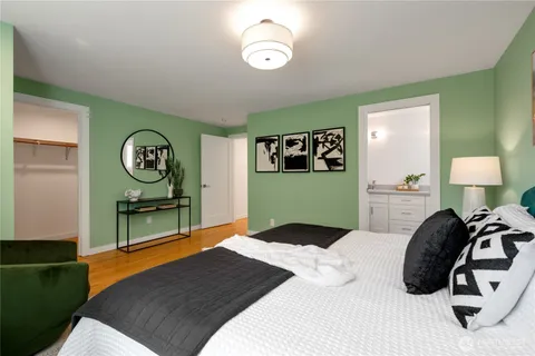 a bedroom with a bed and a lamp on dresser
