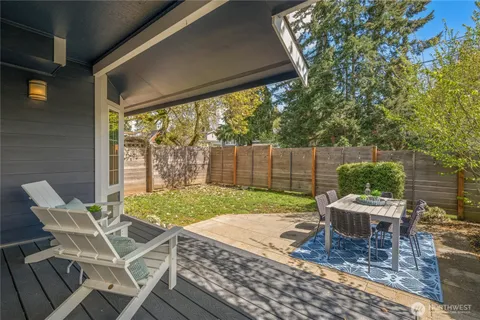 a patio with a table and chairs and potted plants