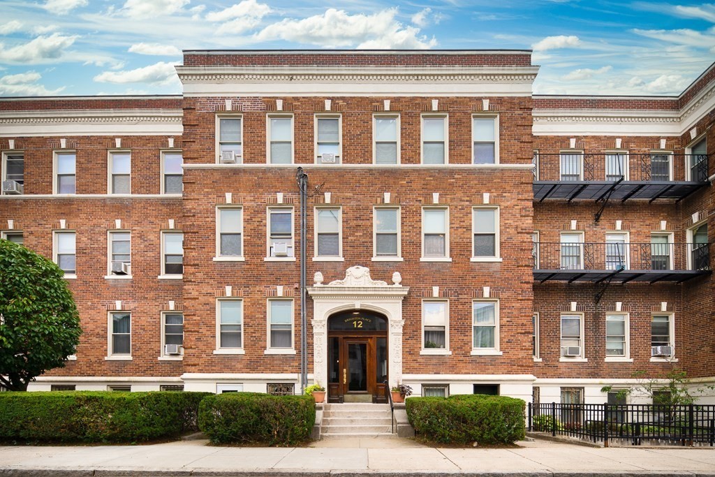 a front view of a building with a garden