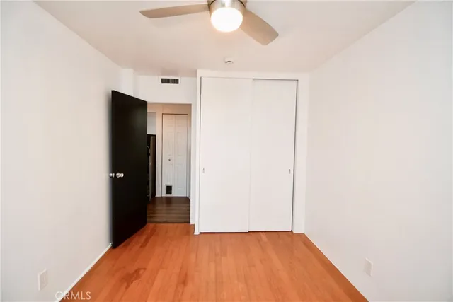a view of a big room with wooden floor and cabinet