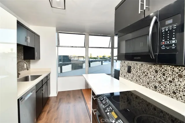 a kitchen with stainless steel appliances kitchen island granite countertop a sink and wooden cabinets