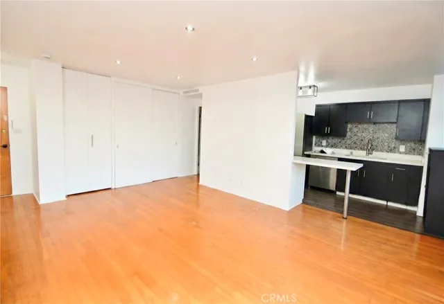 a view of kitchen with sink and refrigerator