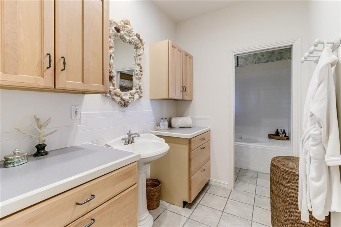 488 Margo Lane Port Aransas, TX 78373 - Photo 20 of 40 a bathroom with a sink a mirror and a bathtub