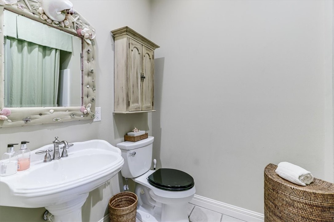 488 Margo Lane Port Aransas, TX 78373 - Photo 23 of 40 a bathroom with a sink a toilet and mirror