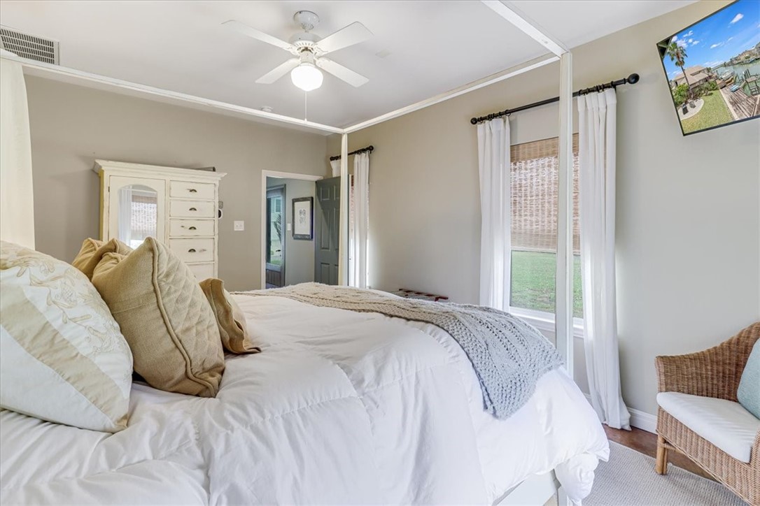 488 Margo Lane Port Aransas, TX 78373 - Photo 27 of 40 a bedroom with a bed and a chandelier