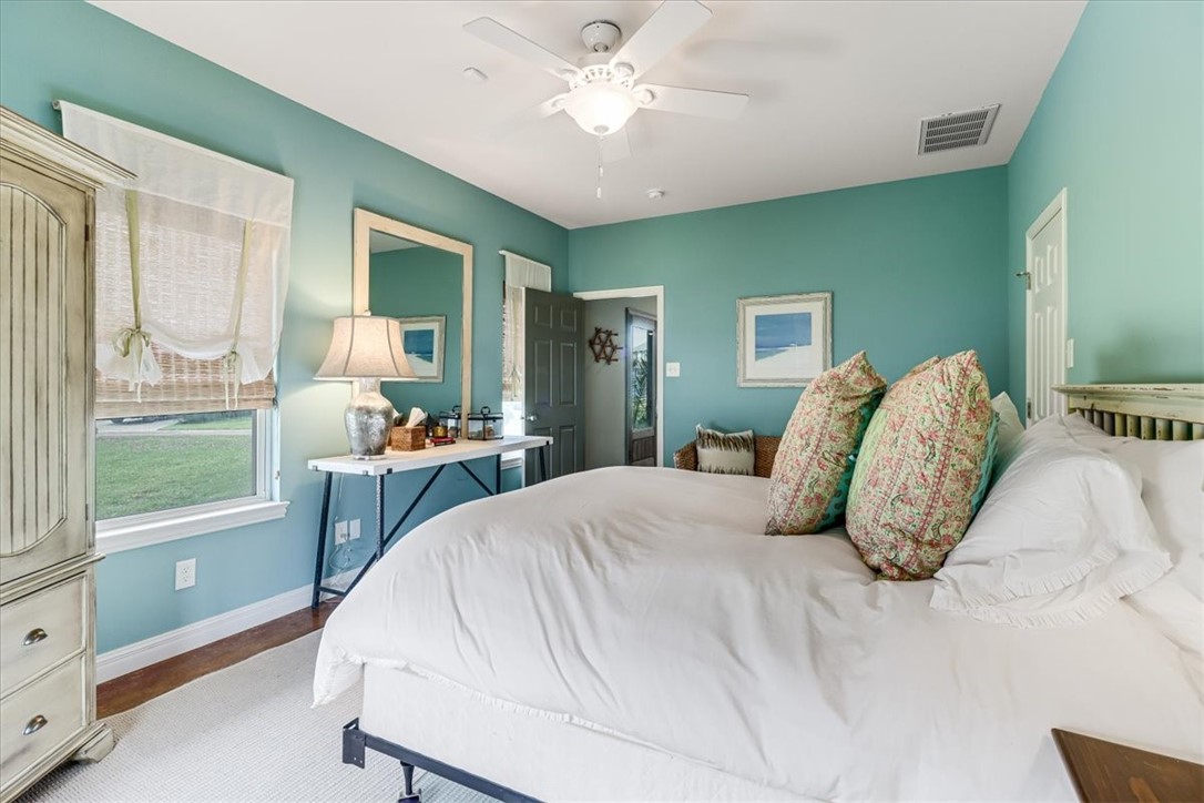 488 Margo Lane Port Aransas, TX 78373 - Photo 29 of 40 a bedroom with a large bed and a chandelier fan