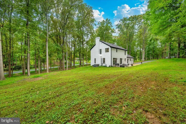a front view of a house with a yard and trees