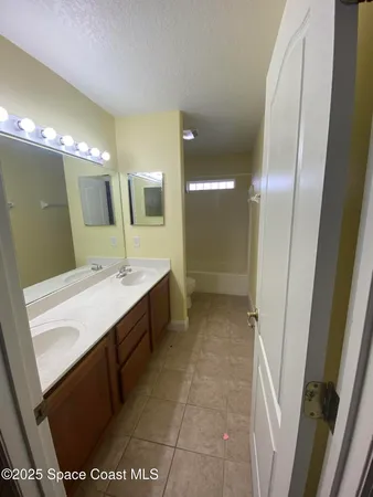 a bathroom with a double vanity sink mirror and shower