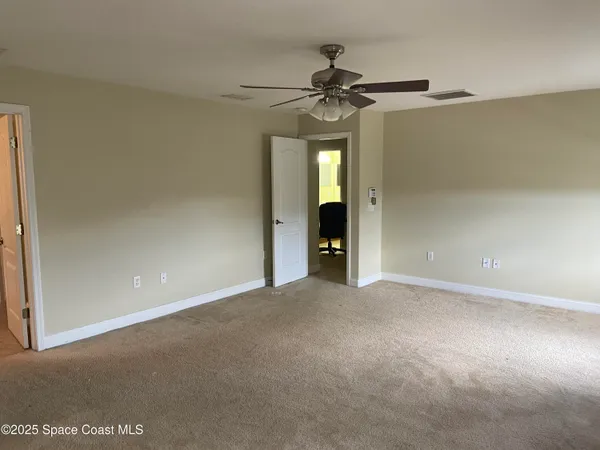 a view of empty room with a ceiling fan and a window