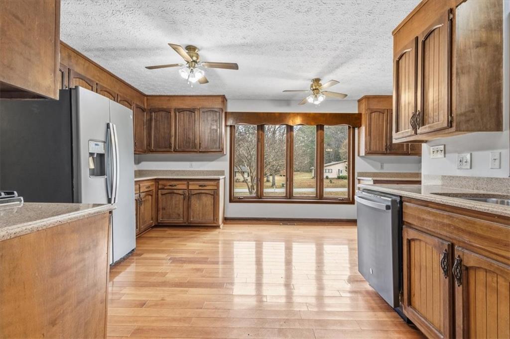 202 Ridgewood Road Cedartown, GA 30125 - Photo 16 of 45 a kitchen with stainless steel appliances granite countertop a refrigerator a sink dishwasher a stove and white countertops with wooden floor