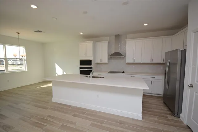 a kitchen with stainless steel appliances a refrigerator sink and cabinets