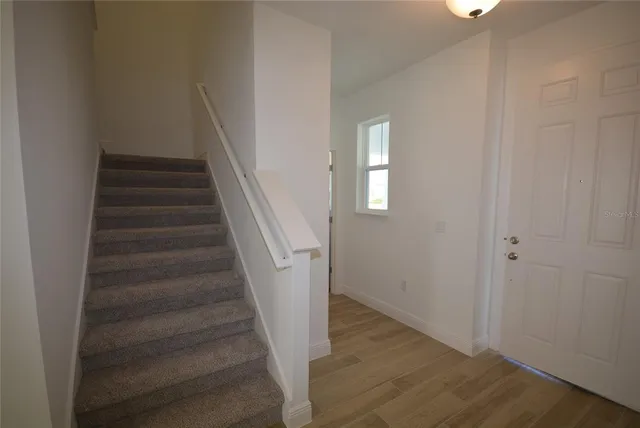 a view of entryway and hall with wooden floor