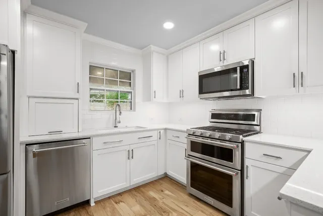 a kitchen with cabinets stainless steel appliances and sink
