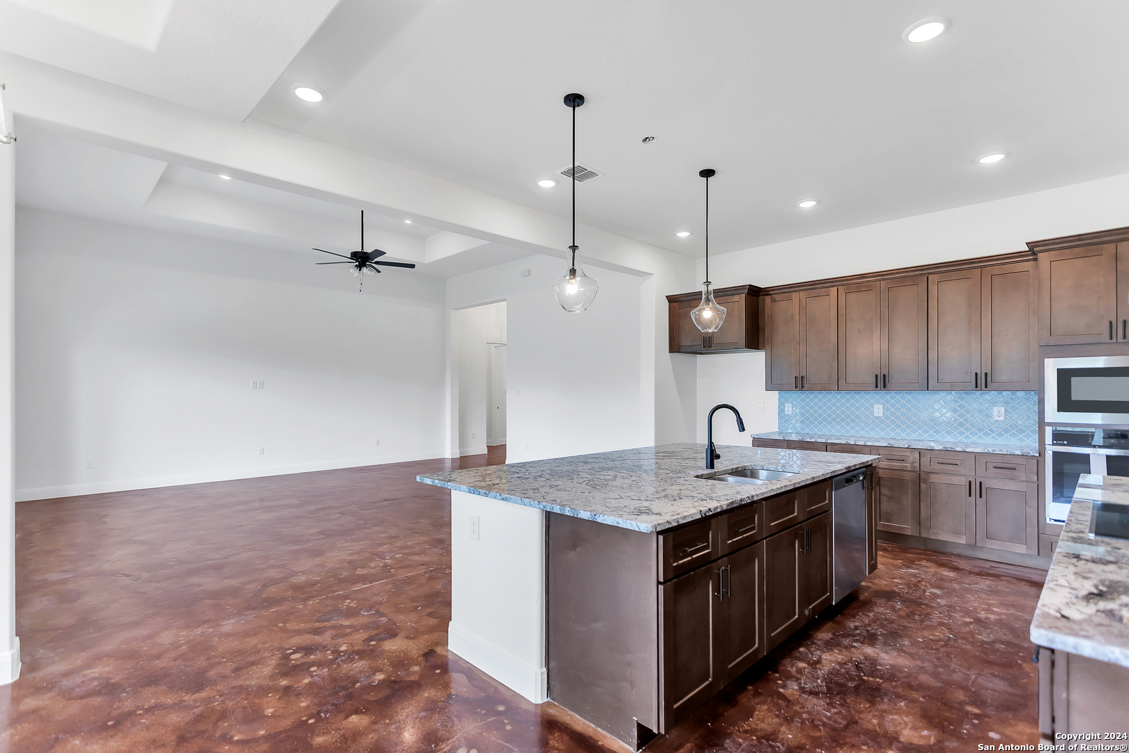 a kitchen with kitchen island a sink counter top space a sink stainless steel appliances and cabinets