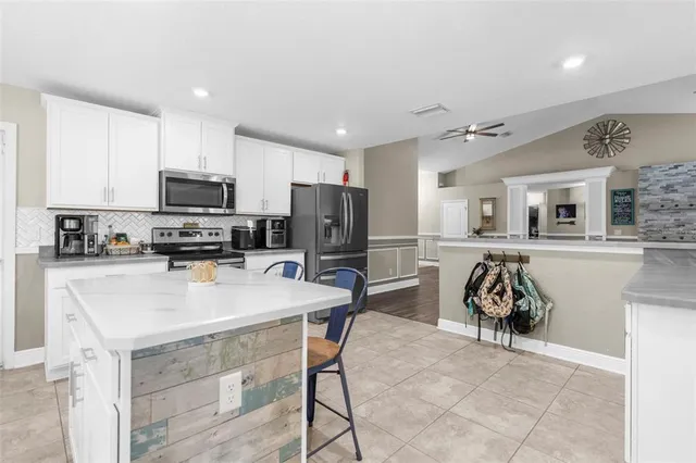 a living room with furniture and a view of kitchen