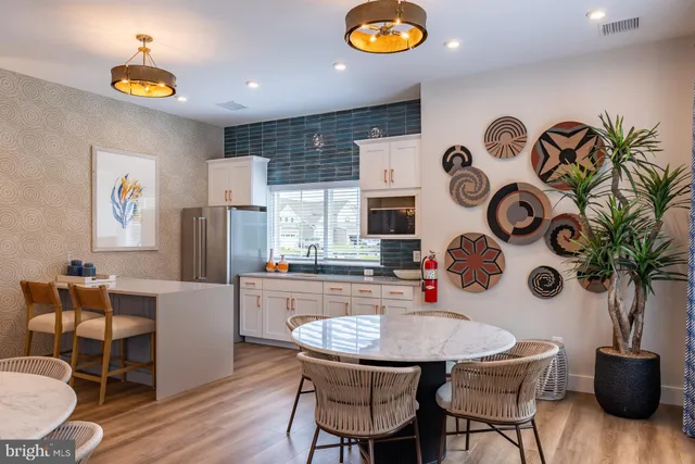 a kitchen with stainless steel appliances granite countertop a dining table and chairs with wooden floor