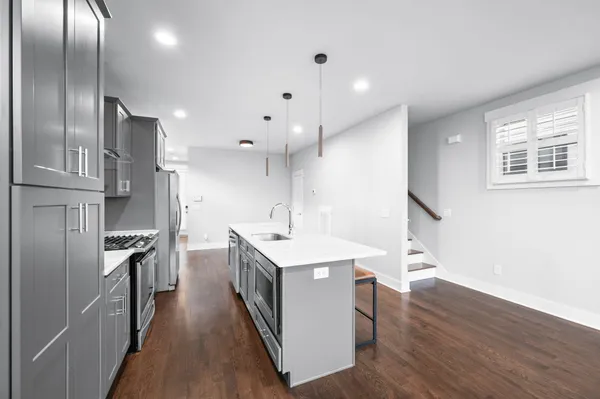a kitchen with kitchen island a sink stove and refrigerator