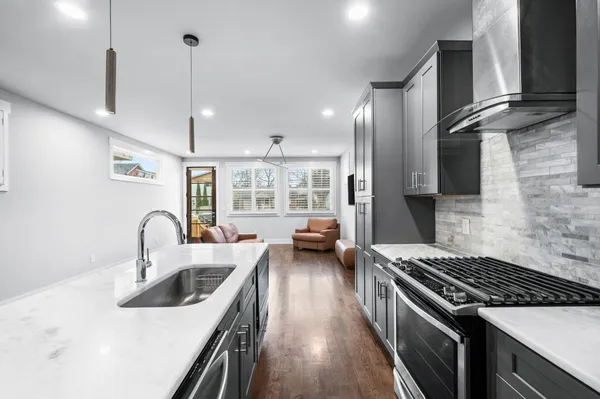 a kitchen with sink a stove and chairs