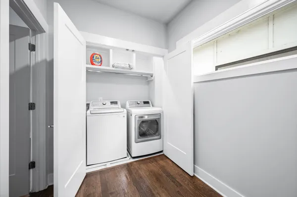 a utility room with wooden floor washer and dryer