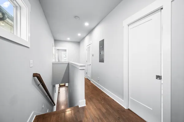 a view of a hallway with furniture and wooden floor