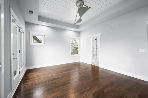 a view of an empty room with wooden floor