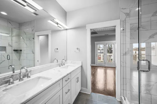 a spacious bathroom with a double vanity sink mirror and shower