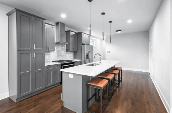 a kitchen with kitchen island a sink appliances and cabinets