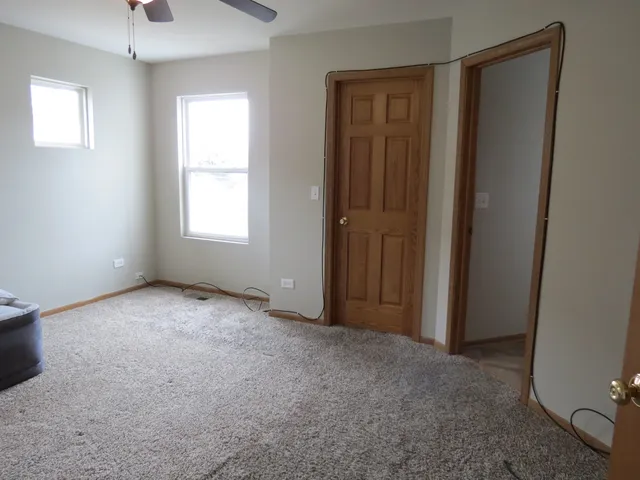an empty room with windows and closet