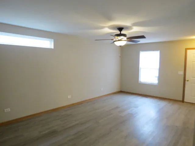 a view of an empty room with window chandelier fan