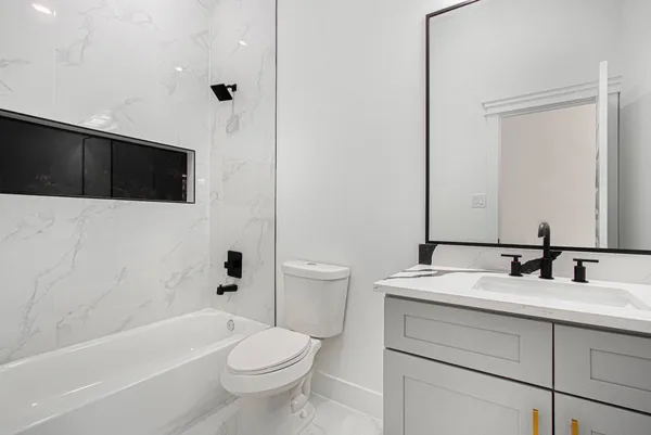 a bathroom with a sink a toilet a mirror and shower