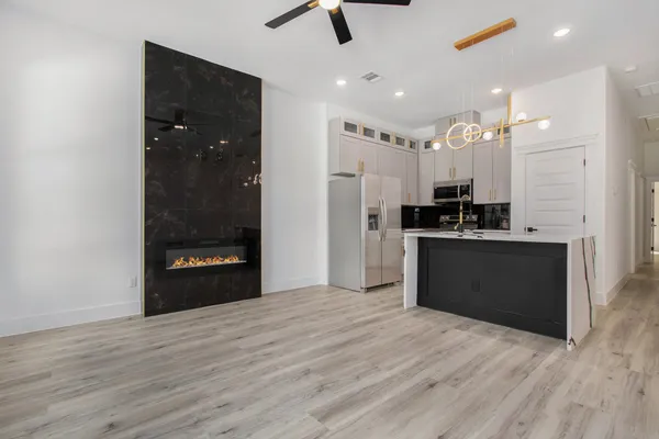 a kitchen with stainless steel appliances kitchen island granite countertop a refrigerator and a sink