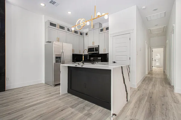 a kitchen with stainless steel appliances a refrigerator sink and microwave