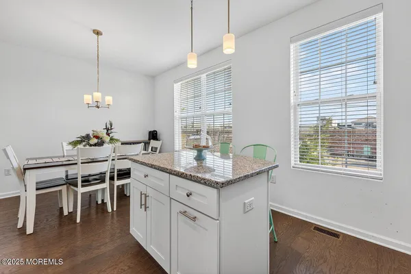 a kitchen with stainless steel appliances granite countertop a stove a chimney a sink and a dining table