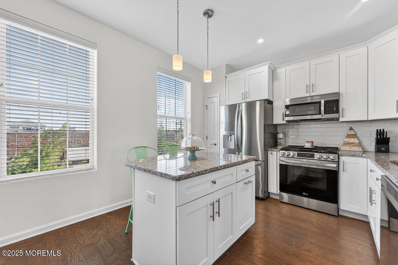 208 Prestige Road Brick, NJ 08723 - Photo 13 of 33 a kitchen with stainless steel appliances kitchen island granite countertop a stove a sink and a refrigerator