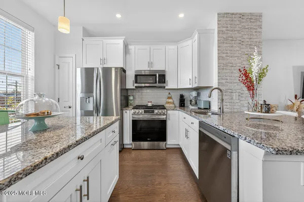 a kitchen with kitchen island granite countertop a sink stove and refrigerator