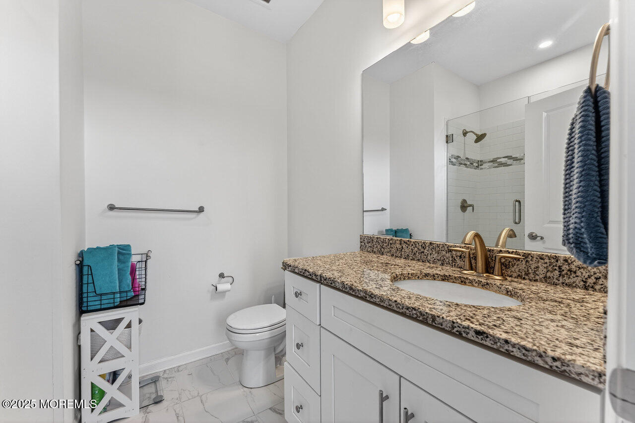 208 Prestige Road Brick, NJ 08723 - Photo 27 of 33 a bathroom with a granite countertop toilet a sink and a mirror