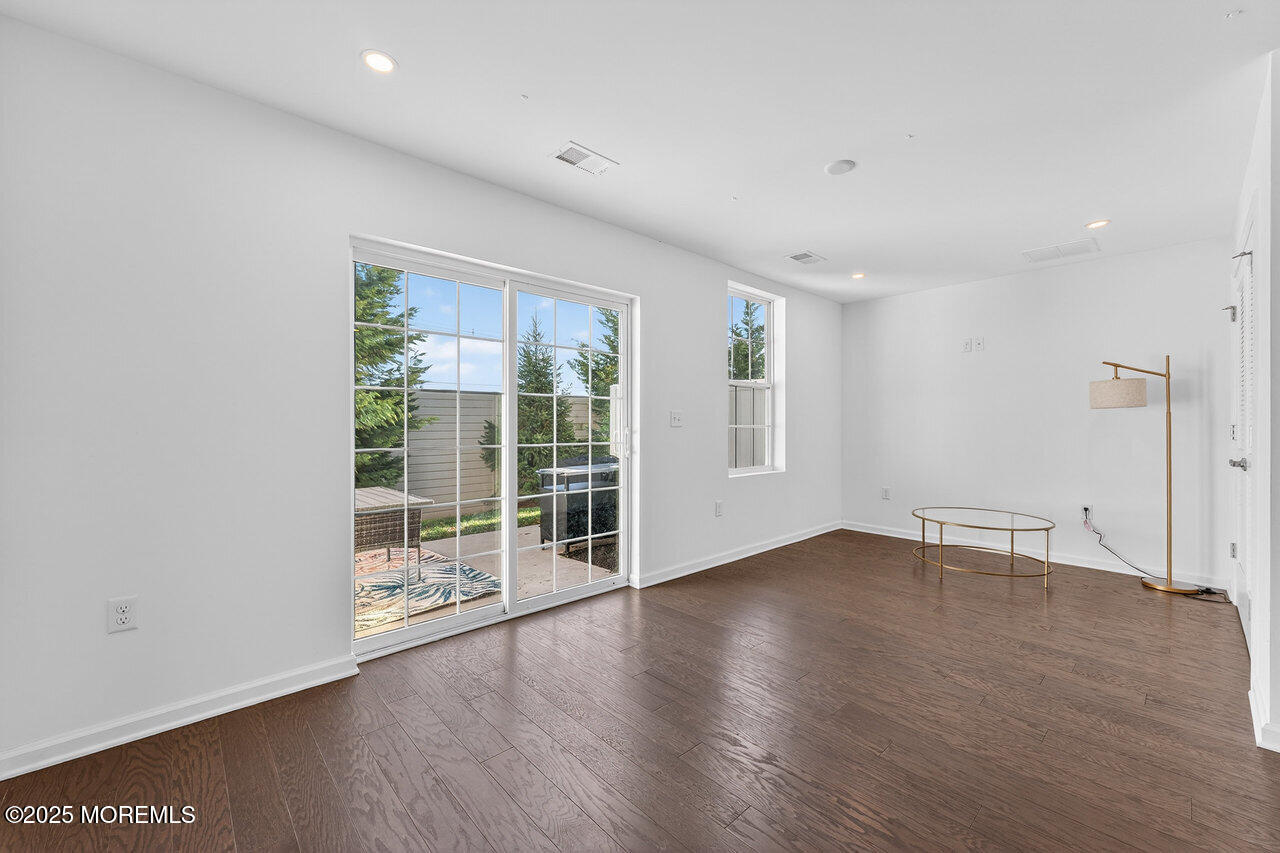 208 Prestige Road Brick, NJ 08723 - Photo 3 of 33 an empty room with wooden floor and windows