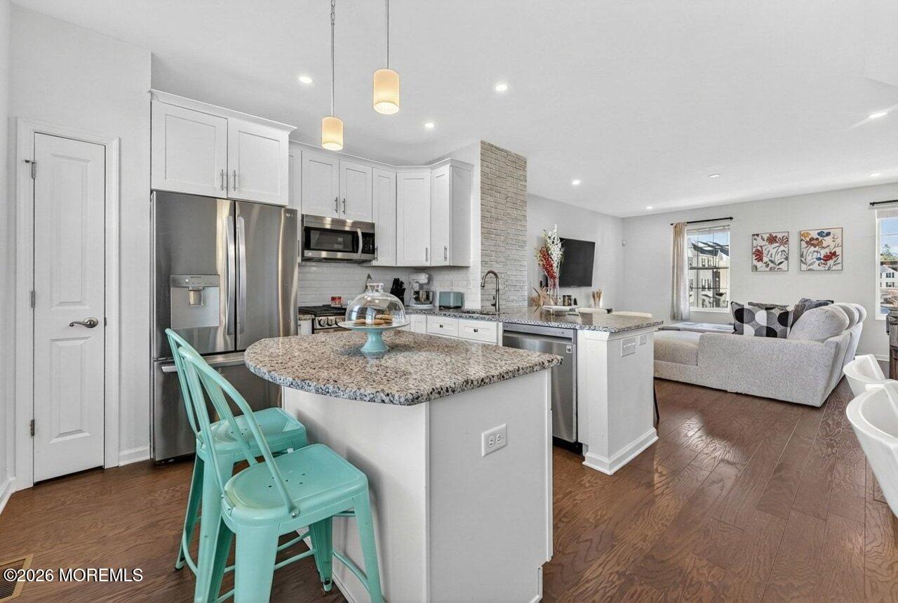 208 Prestige Road Brick, NJ 08723 - Photo 7 of 33 a kitchen with stainless steel appliances granite countertop a table chairs refrigerator and a sink