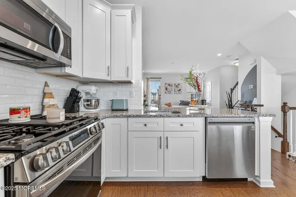 a kitchen with stainless steel appliances granite countertop a sink and cabinets