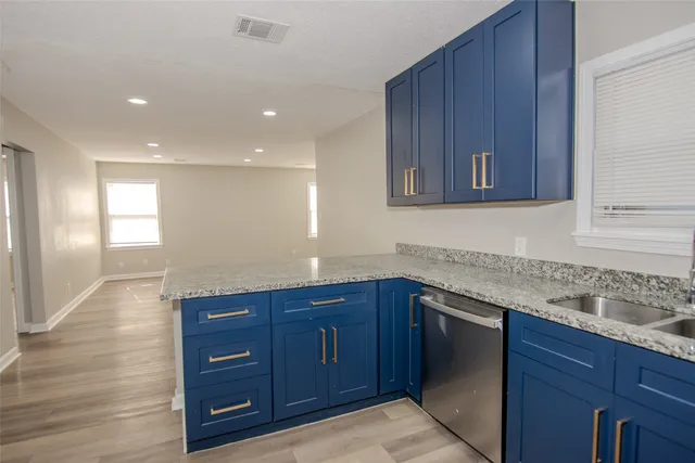 a kitchen with granite countertop wooden cabinets and sink