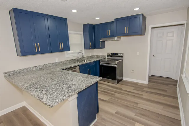 a kitchen with kitchen island granite countertop wooden cabinets a sink and dishwasher