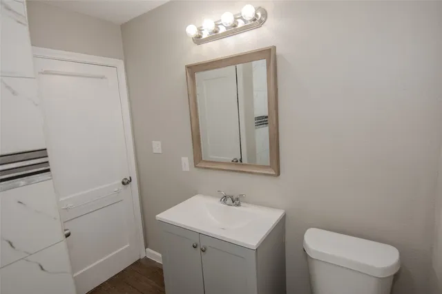 a bathroom with a toilet a sink a vanity and mirror